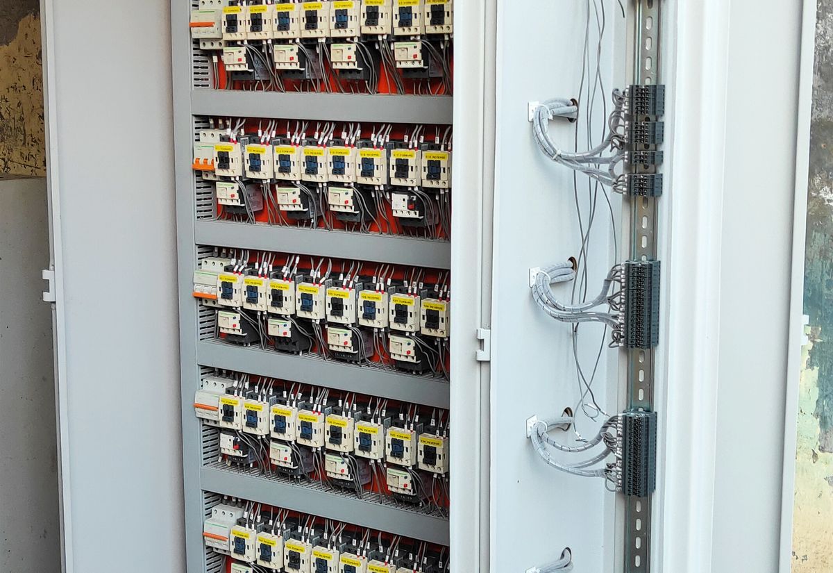 PLC control panel with relay interface cards and labelled forward reverse contactors