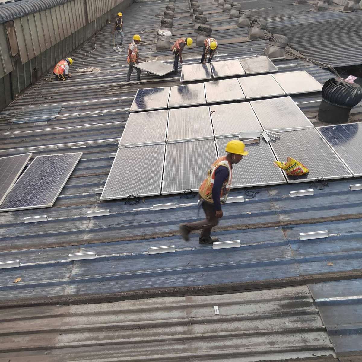 Solar module installation in progress on an industrial roof